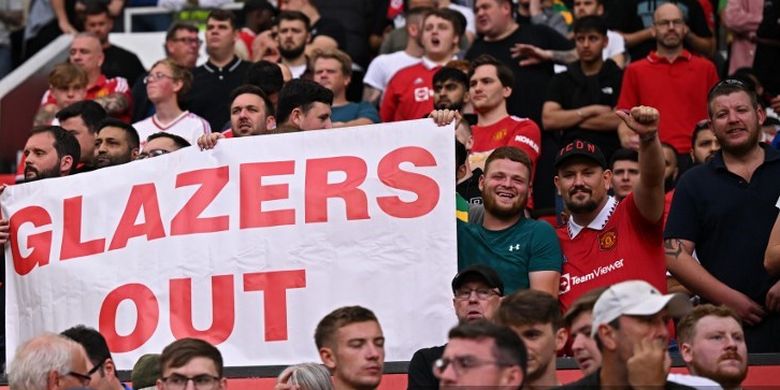 Fan Man United membentangkan spanduk 'Glazers Out' saat laga Man United vs Arsenal dalam lanjutan Liga Inggris di Stadion Old Trafford pada 4 Septemberr 2022. (Foto oleh Oli SCARFF / AFP) 