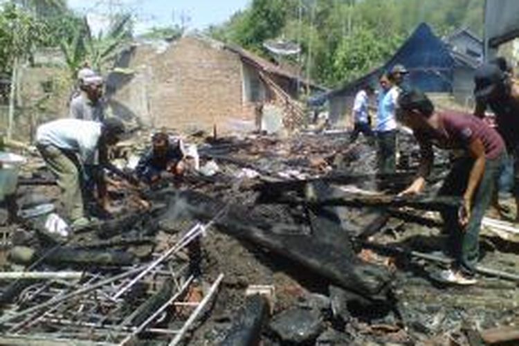 Warga Dusun Rowo Desa Pakusari Kecamatan Pakusari, Jember Jawa Timur, membantu mencari barang berharga milik korban kebakaran, Senin (7/10/13) 