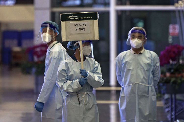 Seorang pekerja dari China Eastern memegang papan nama menunggu kerabat para korban penerbangan China Eastern MU5735, di Bandara Internasional Guangzhou Baiyun di Guangzhou, Provinsi Guangdong, China Selatan, Senin (21/3/2022). Pada Kamis (29/12/2022), otoritas Italia mengatakan lebih dari separuh penumpang dalam pesawat dari China ke Milan ditemukan positif Covid-19.