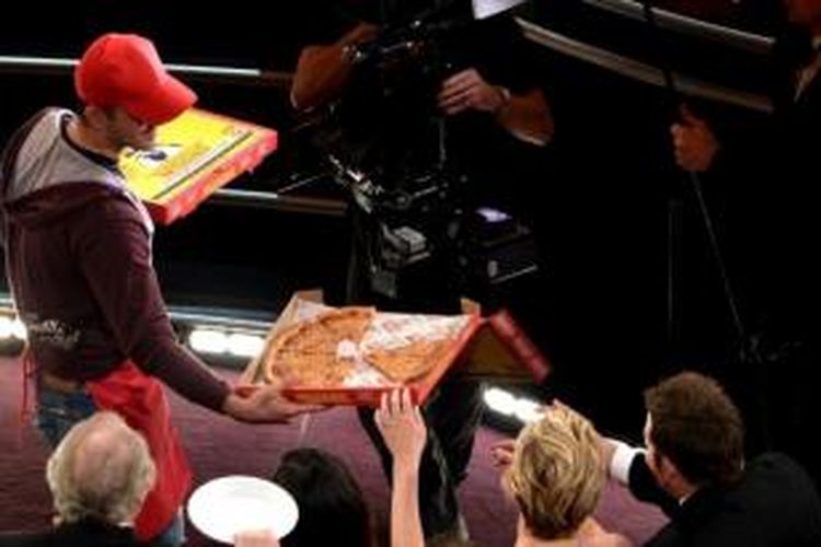 Pengantar pizza membagikan makanan kepada penonton saat pengumuman Oscar 2014.