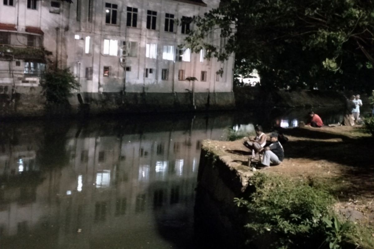 Warga memancing di aliran sungai dekat Stasiun Juanda, Sawah Besar, Jakarta Pusat, Kamis (6/9/2018).