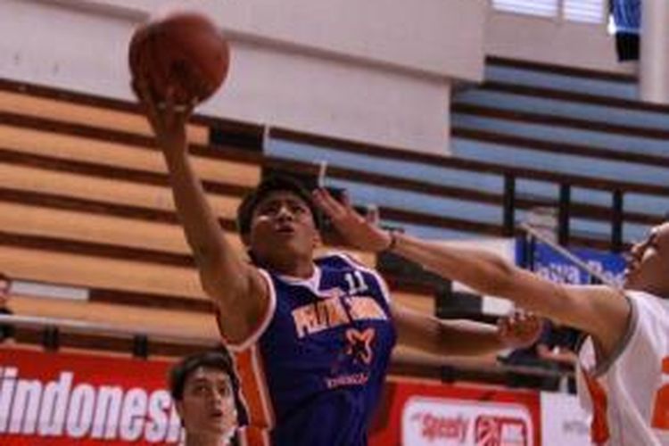 Rookie Pelita Jaya Energi-MP Jakarta, Andrey Rido Mahardika (tengah), melakukan lay-up saat berhadapan dengan NSH GMC Riau, di DBL Arena Surabaya, Senin (23/9/2013).