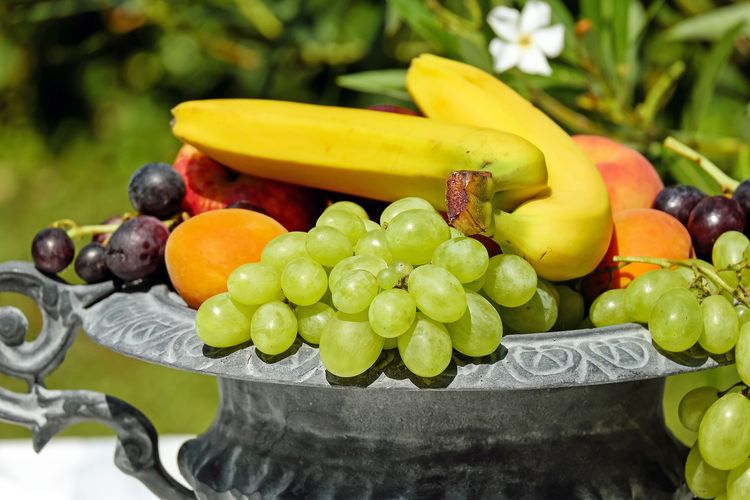 Ilustrasi buah-buahan seperti pisang dan anggur.