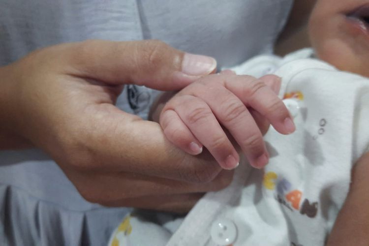 Jemari mungil Anya Ghania menggenggam tangan ibunya, Baeti yang telah berjuang sembilan bulan mengandung dan melakukan persalinan caesar, Minggu (23/7/2023).
