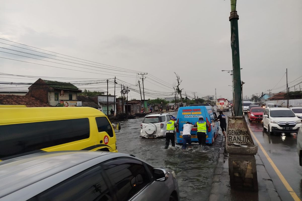 Anggota Satlantas Polres Demak, saat mendorong kendaraan yang mogok saat melintas dari Pantura Sayung, Kabupaten Demak, Jawa Tengah (Jateng). 