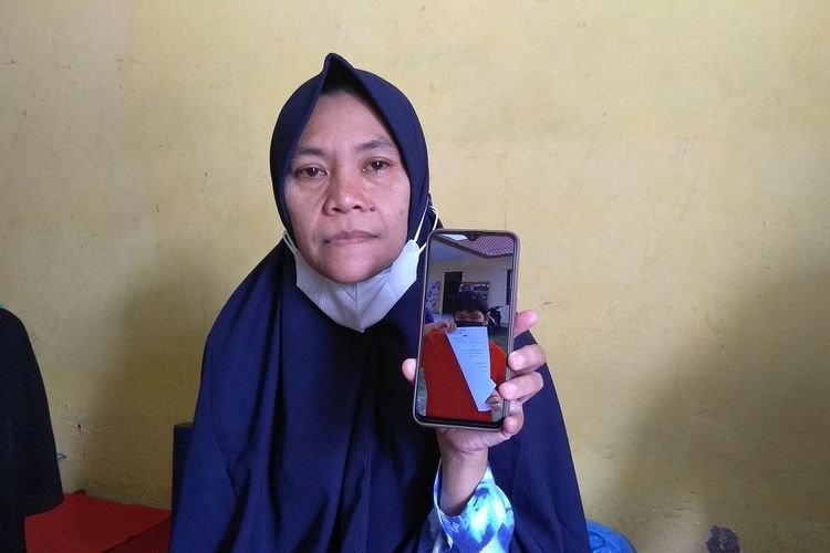 Lia Pratiwi (42) menunjukkan foto anaknya, M. Reza Aulia (10) membawa berkas laporan di Polsek Tuntungan pada Jumat (11/6/2021). Sebelum meninggal dunia pada Minggu (13/6/2021), Reza digigit anjing pada Kamis (10/6/2021). Kondisinya dari hari ke hari semakin memburuk. Pihak keluarga membuat laporan ke polisi lantaran tidak ada itikad baik dari pemilik anjing.