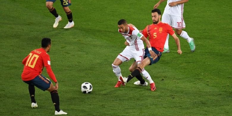 Gelandang Maroko, Hakim Ziyech, dijaga pemain Spanyol, Sergio Busquets, pada pertandingan Grup B Piala Dunia 2018 di Kaliningrad, 25 Juni 2018. 