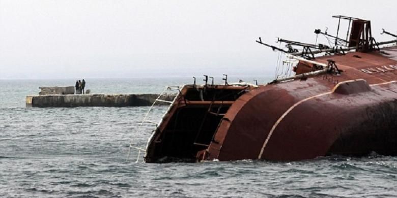 Sejumlah orang menonton saat kapal perang kapal anti-kapal selam Rusia, Ochakov, ditenggelamkan pada Kamis (6/3/2014) oleh pasukan Rusia di pantai Laut Hitam di luar kota Myrnyi, Crimea Barat.