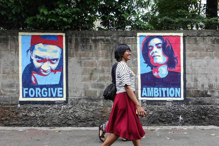 Warga kampung melintas di tembok-tembok berlabur mural yang bernarasi empati dan kepedulian terhadap sesama karya para seniman sreet art pada 2016.