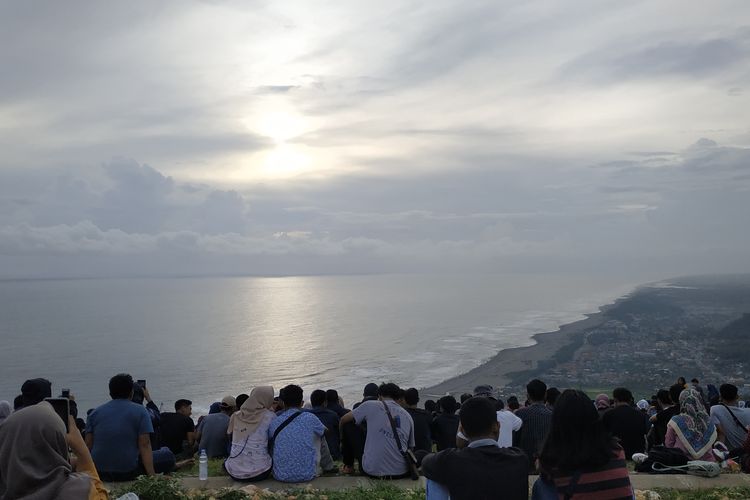 Suasana di Bukit Paralayang Watugupit, Yogyakarta. Wisatawan tengah menikmati pemandangan ke arah pantai selatan dan Samudera Hindia.
