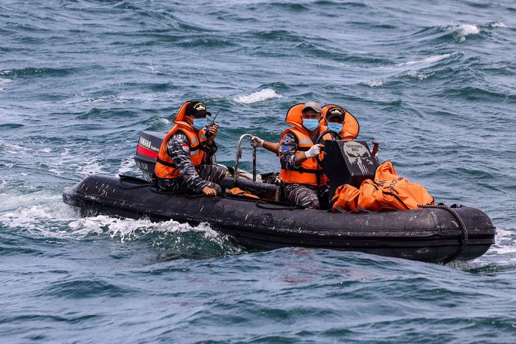 Indonesian Navy personnel take fragments from Sriwijaya Air Flight SJ 182 to the Indonesian Navy Ship KRI Tenggiri-865 in waters around the Thousand Islands, Tuesday (12/1/2021)