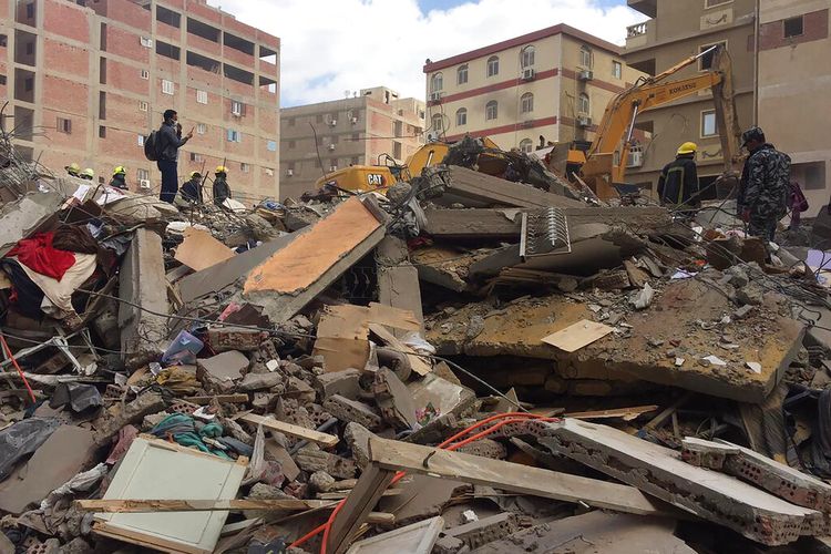 Pekerja darurat menyaring puing-puing gedung apartemen yang runtuh di lingkungan el-Salam, Sabtu, 27 Maret 2021, di Kairo, Mesir. 