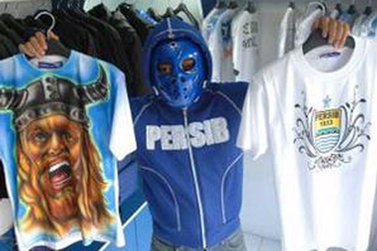Seorang penjaga toko memperkenalkan kaos Viking dan Persib di outlet Real Supporter di Stadion Persib, Jalan Ahmad Yani, Bandung, Jawa barat. 