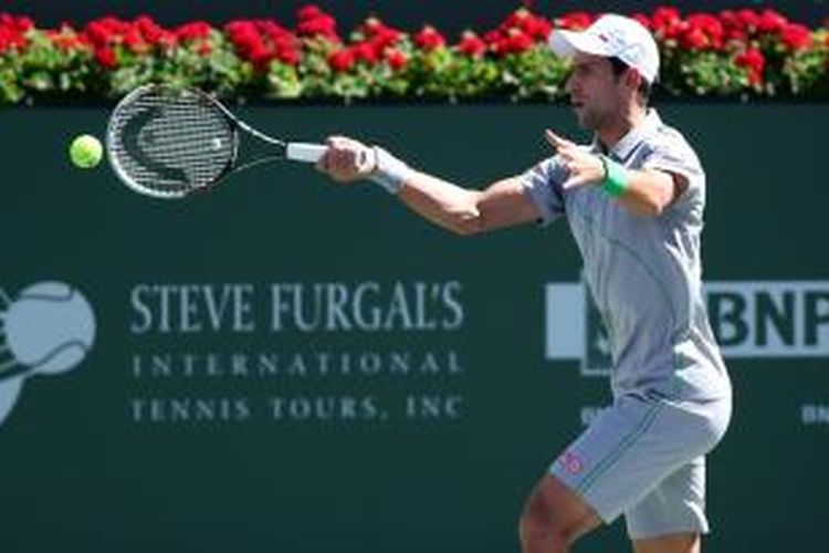 Petenis Serbia Novak Djokovic memukul bola dari petenis Swiss Roger Federer pada laga final BNP Paribas Open di Indian Wells, Minggu (16/3/2014).