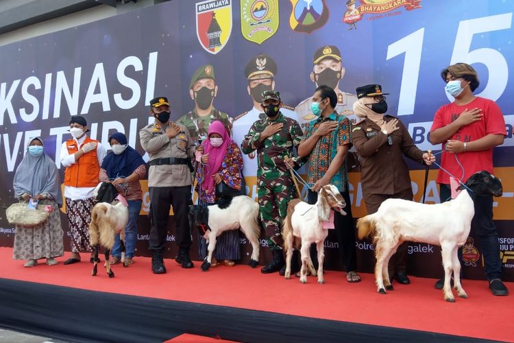 Sejumlah warga yang mendapat hadiah ayam hingga kambing usai mengikuti vaksinasi massal di Pasar Pon Trenggalek, Kamis (24/6/2021).