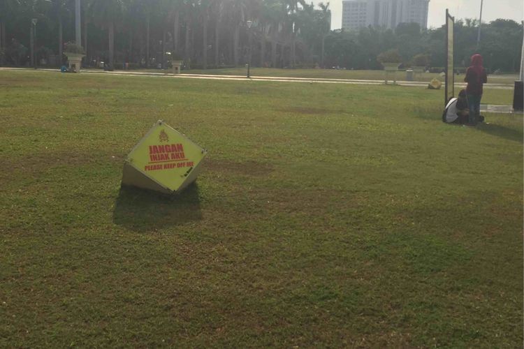 Petugas perawatan taman di Monas menyebut rumput taman di kawasan Monas mulai menguning setelah Pemprov DKI Jakarat memperbolehkan pengunjung menginjak rumput taman, Sabtu (13/1/2018).