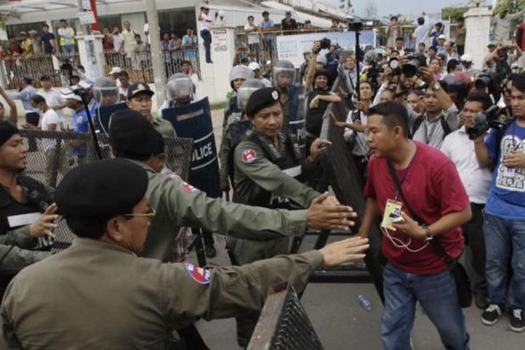 Polisi anti-huru-hara menghalangi jurnalis memasuki jalan utama yang diblokir di dekat kantor pusat Partai Penyelamatan Nasional (CNRP) di Phnom Penh, Kamboja.  