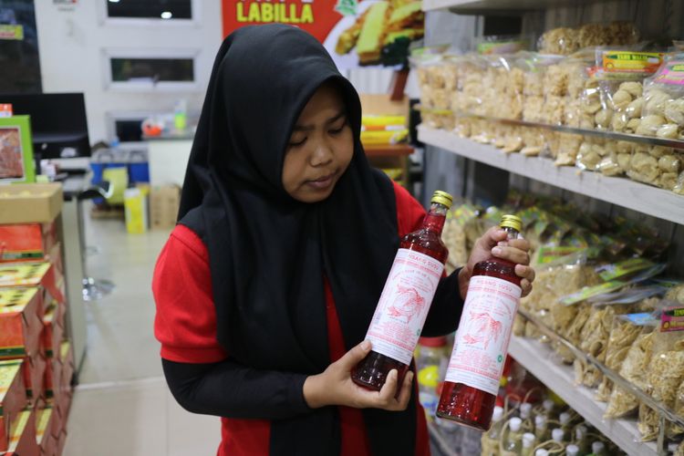 Seorang pelayan di pusat oleh-oleh DaudCirebon, sedang menunjukan Sirup Tjampolay yang merupakan minuman khas Cirebon, Selasa (5/8/2017).