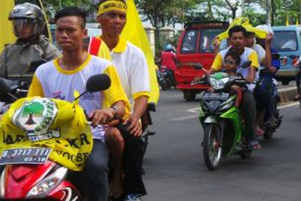 Massa pendukung Golkar yang melintasi Jalan Raya Bogor, depan lokasi GOR Ciracas tempat Golkar melakukan kampanye di Jakarta Timur. Selasa (18/3/2014).