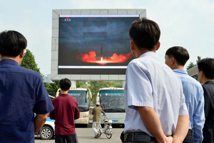 Warga melihat laporan berita menunjukkan peluncuran rudal balistik jarak-menengah Hwasong-12 melalui layar elektronik di stasiun Pyongyang, Korea Utara, dalam foto yang diambil Kyodo, Rabu (30/8/2017).