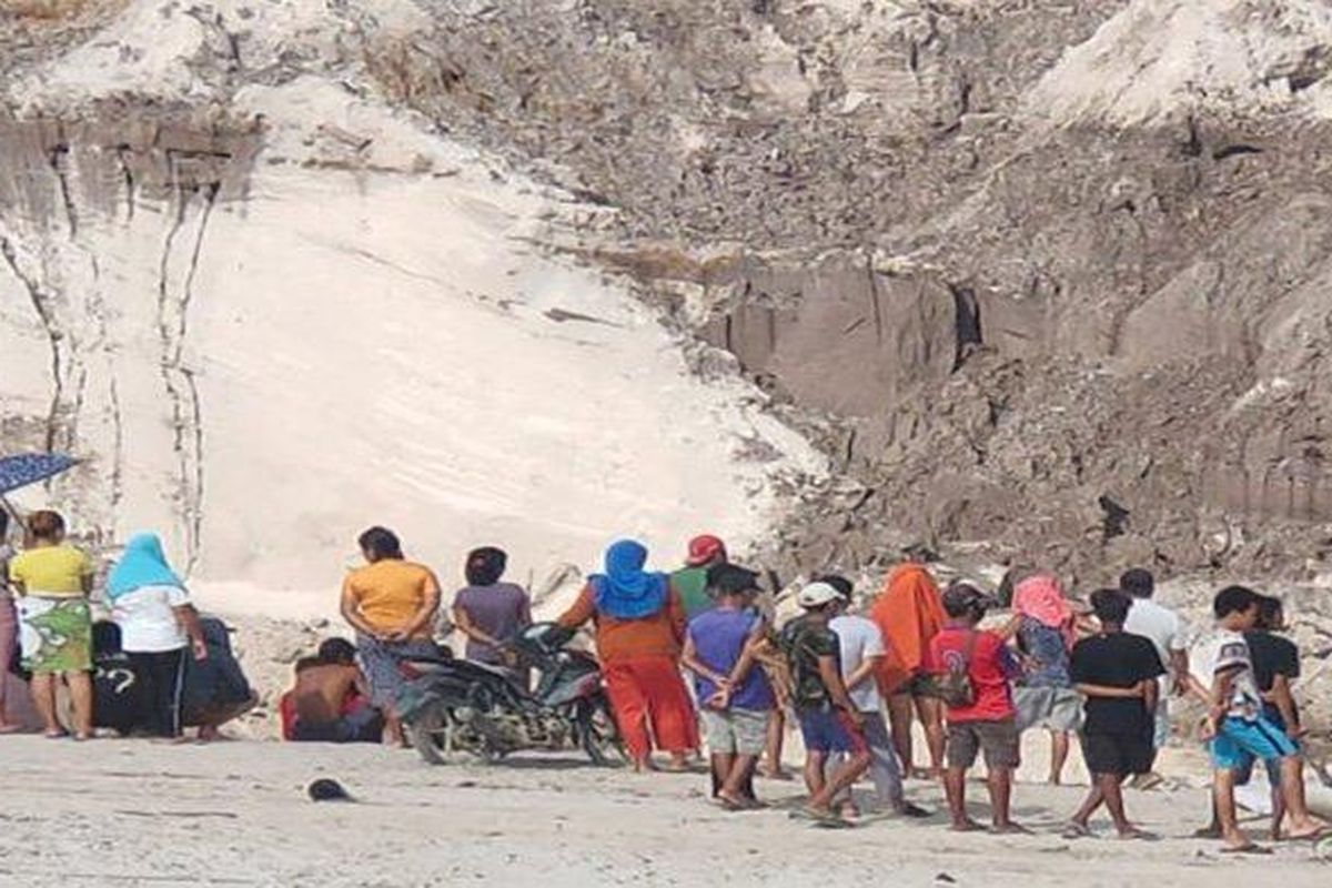 People gather near the area of a landslide on Thursday, April 1.