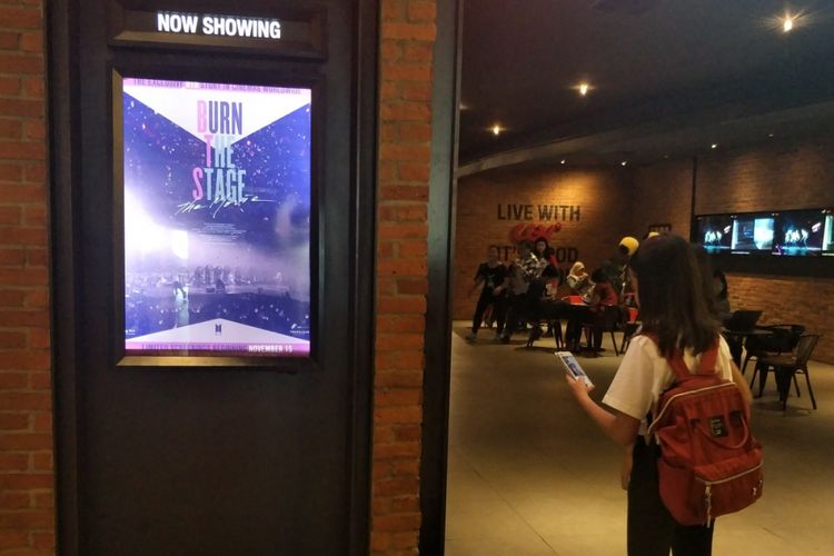 Seorang penggemar cilik boyband BTS yang disebut ARMY memotret poster film dokumenter BTS berjudul Burn The Stage di CGV Grand Indonesia, Jakarta Pusat, Kamis (15/11/2018) malam.