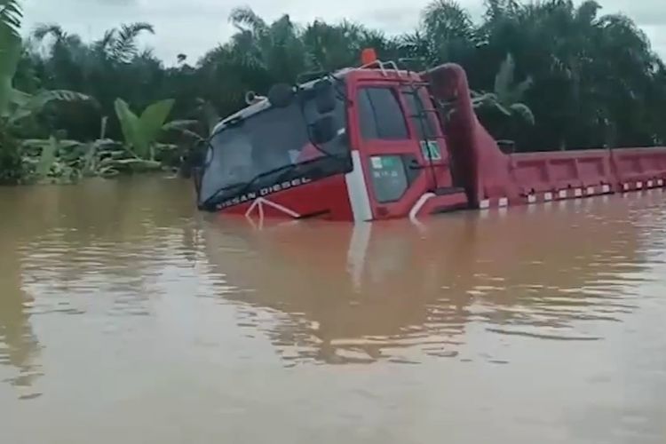 Sebuah truk terjebak banjir yang menggenangi jalan lintas yang menghubungkan Kalsel Kaltim di kilometer 400, di Kecamatan Sungai Durian, Kotabaru, Rabu (9/11/2022). 
