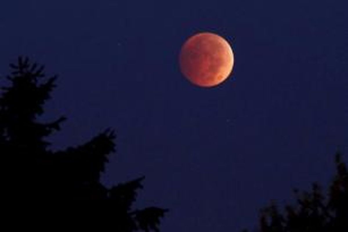 Gerhana bulan terlihat dari Erie, Pennsylvania, 8 Oktober 2014. Warna merah pada gerhana bulan dipengaruhi oleh pembiasan atmosfer Bumi, disebut dengan 'bulan merah darah'.