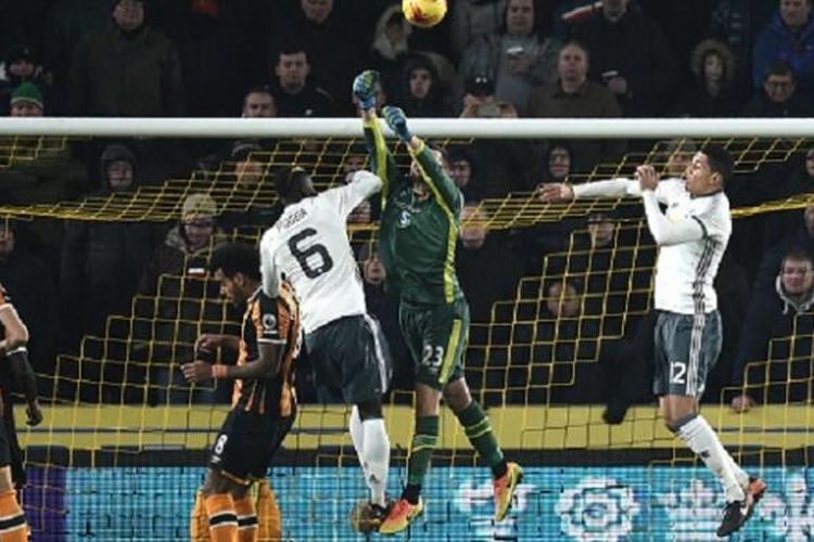 Kiper Hull, David Marshall, meninju bola yang coba disambut dua pemain Manchester United, Paul Pogba dan Chris Smalling, pada semifinal kedua Piala FA, Kamis (26/1/2017). 