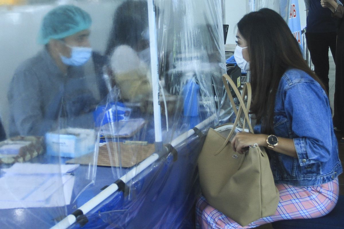 Seorang warga Jakarta mendaftar untuk melakukan pemeriksaan rapid tes antigen di Bandara Sultan Mahmud Badaruddin II Palembang, sebagai salah satu syarat penerbangan, Jumat (24/12/2020).