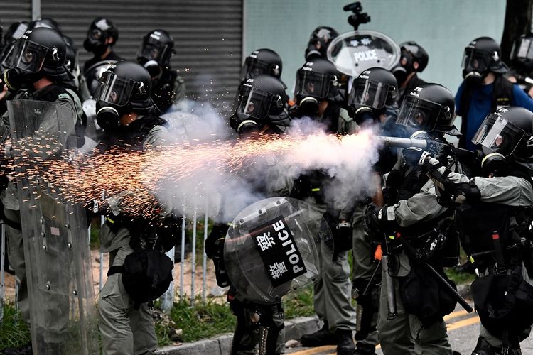Petugas polisi anti-huru hara menembakkan gas air mata ke arah massa pengunjuk rasa dalam aksi protes di Yuen Long, Hong Kong, Sabtu (27/7/2019).