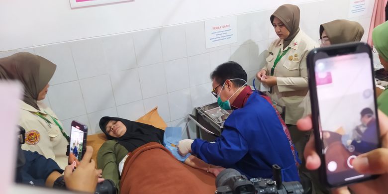 Kepala BKKBN dr Hasto Wardoyo memasang implan kepada seorang ibu saat melayani pemasangan alat kontrasepsi di Klinik Siliwangi pada gelaran puncak peringatan Hari Kontrasepsi Sedunia atau World Contraception Day (WCD) 2023 di Kota Cimahi, Jawa Barat, Senin (23/10/2023). 