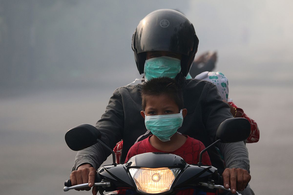 Pengguna jalan menggunakan masker yang dibagikan petugas kesehatan dari Puskesmas Cot Simeureung, Kecamatan Samatiga dan Layung, Kecamatan Bubon, Kabupaten Aceh Barat, menyusul kabut asap kebakaran hutan dan lahan gambut yang sangat pekat, Kamis (1/8/2019). Selain kepada pengguna jalan, masker juga dibagikan kepada siswa empat sekolah yang terdampak kabut asap di Kecamatan Samatiga, yang berada di Desa Suak Timah dan Desa Blang Bale.