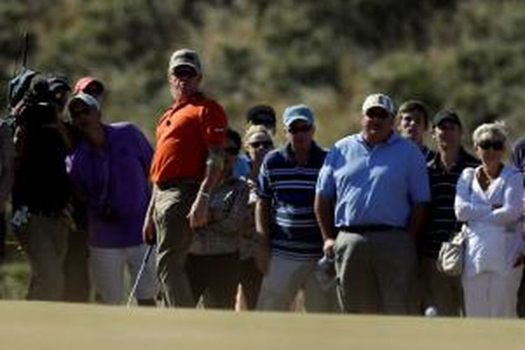 Pegolf Spanyol, Miguel Angel Jimenez (kaus merah), melihat ke arah bola yang dia pukul di green ke-16, pada putaran kedua The Open Championship, di Muirfield, Skotlandia, Jumat (19/7/2013).