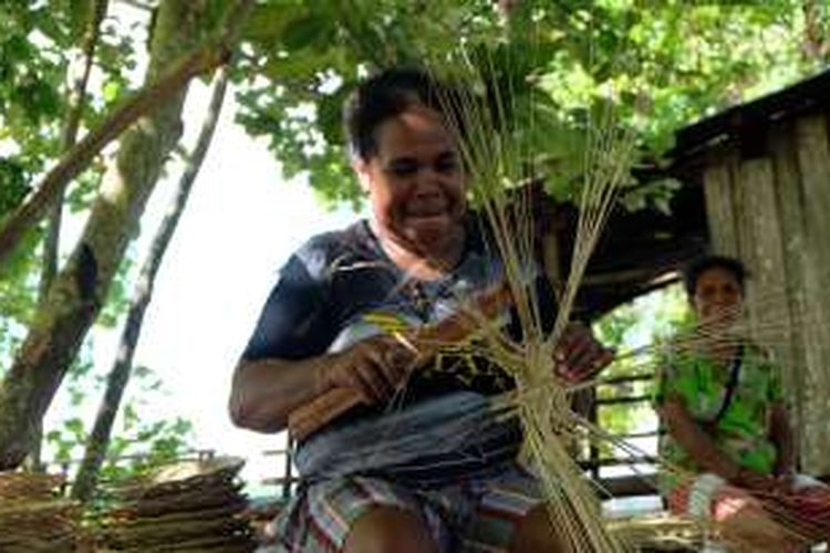 Mama Yuliana dengan cekatan membuat piring dari lidi.