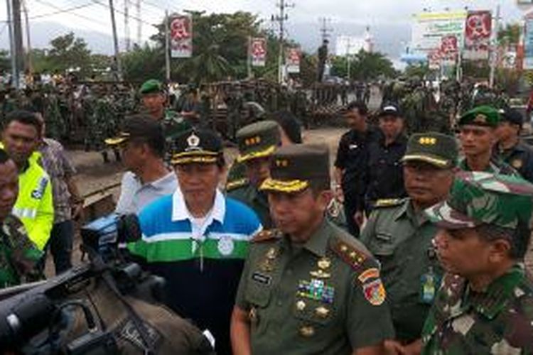 Anggota TNI memasang jematan darurat untuk menghubungkan ruas jalan utama yang putus di Manado.