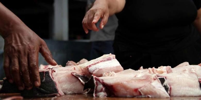 Seorang pembeli sedang menawar daging ikan hiu yang dijual di pasar tradisional Tagulandang, Kabupaten Kepulauan Sitaro, Sulawesi Utara, Sabtu (25/5/2013). Perairan Sulawesi Utara kerap dijadikan tempat berburu ikan hiu. Hasil tangkapan diolah dan dijual kembali dengan harga tinggi.
