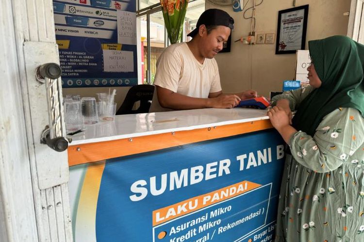 AgenBRILink Sarip Hidayat saat berinteraksi dengan nasabah yang merupakan petani di sekitar wilayahnya.