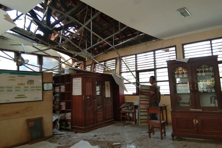 Warga dan penjaga sekolah tengah mengamankan barang di ruang guru SDN Kalangsuria III yang ambruk, Senin (30/9/2109).