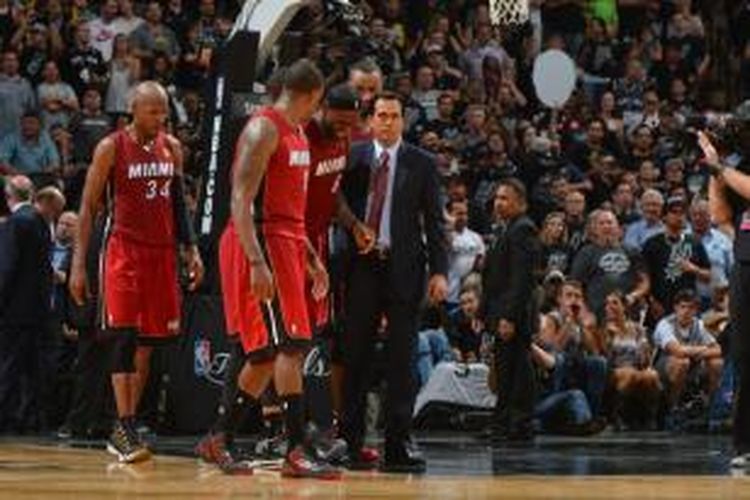 Pelatih Miami Heat, Erik Spolestra (kanan), dan pemain lain membantu LeBron James berjalan menuju bench setelah mengalami kram pada pertandingan pertama final NBA 2014 melawan San Antonios Spurs di AT&T Center, Kamis (5/6/2014). Spurs menang 110-95.