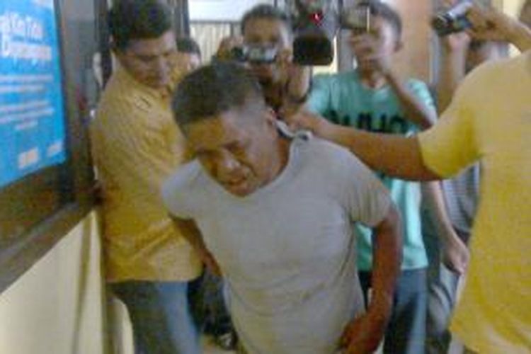 AS (43) seorang dukun cabul yang memerkosa salah satu pasiennya saat digiring petugas Polres Pulau Ambon ke ruang tahanan, Rabu (23/10/2013)