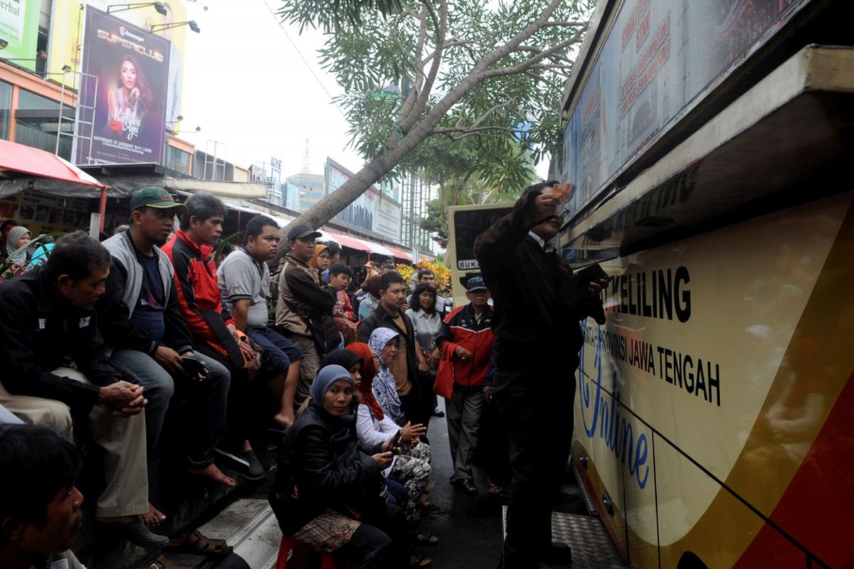 Warga mengantre untuk membayar pajak kendaraan bermotor melalui mobil Samsat Keliling di kawasan Simpang Lima, Kota Semarang, Jawa Tengah, Kamis (5/1/2017). Pemerintah mulai memberlakukan tarif baru biaya pengurusan surat-surat kendaraan dengan kenaikan dua hingga tiga kali lipat dari sebelumnya.