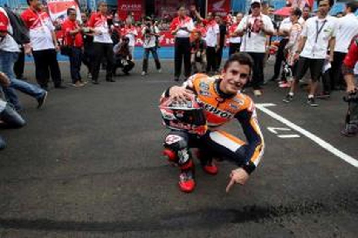 Juara dunia MotoGP, Marc Marquez memperlihatkan aspal Sirkuit Sentul yang terkelupas saat ia memacu Honda RCV di Sirkuit Sentul, Bogor, Jawa Barat, Selasa (21/10/2014). Marc Marquez dan rekan satu timnya Dani Pedrosa datang ke Jakarta untuk bertemu penggemarnya.