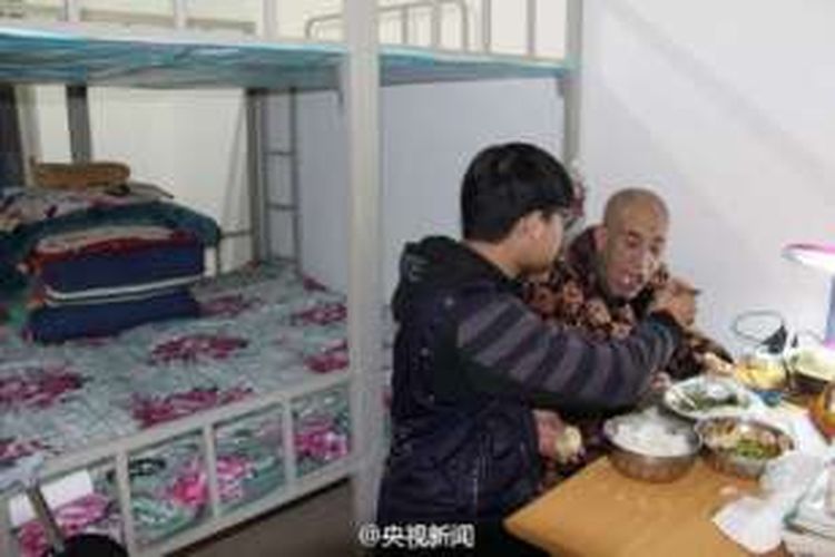 Zhao Delong menyuapi ayahnya yang sakit dan lumpuh di salah satu kamar asrama kampusnya di Henan, China. Demi merawat ayahnya yang sakit, Zhao membawa sang ayah untuk tinggal di asrama kampusnya.