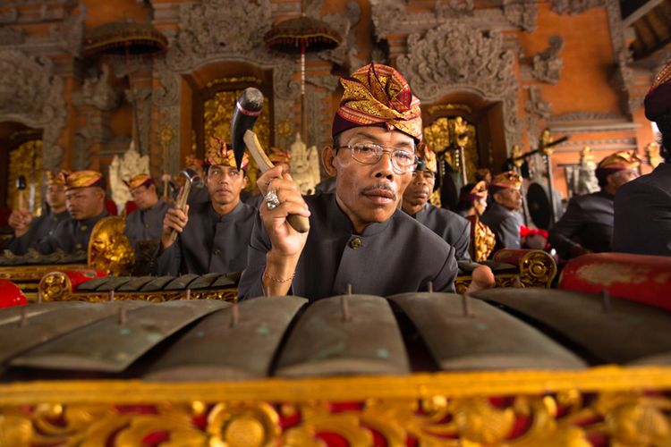 UBUD, BALI, INDONESIA - NOV 1: A man plays traditional gamelan percussion during the ceremony of the cremation of the Queen on November 1, 2013 in Ubud, Bali.