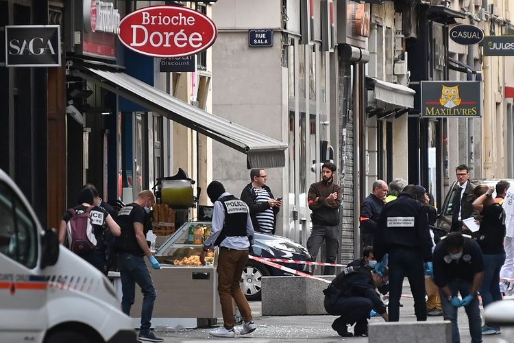 Polisi Perancis mencari barang bukti di depan toko roti Brioche doree setelah ledakan yang dicurigai sebagai paket bom di sepanjang pedestrian di jantung kota Lyon, Perancis, Jumat (24/5/2019). (AFP/PHILIPPE DESMAZES)