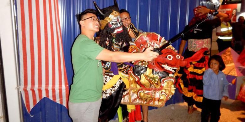 Wisatawan berfoto bersama seorang penari Jaranan Buto Banyuwangi di kawasan perbelanjaan Lot 10, Kuala Lumpur, Malaysia, Sabtu (3/9/2016). Tarian itu ditampilkan oleh para tenaga kerja Indonesia yang berasal dari Banyuwangi, Jawa Timur. Mereka yang tergabung dalam Ikatan Keluarga Banyuwangi (Ikawangi) ini menjadi bagian dari penari yang terlibat dalam ajang Indonesia Street Festival yang digelar Kementerian Pariwisata untuk menarik minat wisatawan Malaysia berkunjung ke Indonesia.