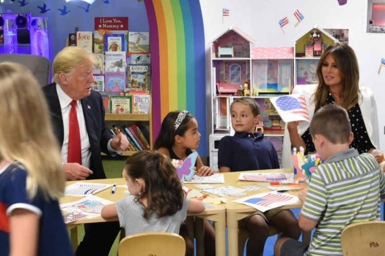 Presiden Amerika Serikat Donald Trump dan Ibu Negara AS Melania Trump mewarnai bendera AS bersama dengan anak-anak di Rumah Sakit Anak di Columbus, Ohio, Sabtu (25/8/2018). (Twiter/Alex Azar)