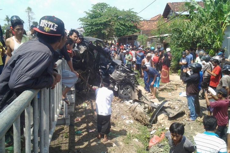 Warga saat berkerumun melihat mobil avanza yang tertabrak kereta api. Kompas. Ckm/ Slamet Priyatin