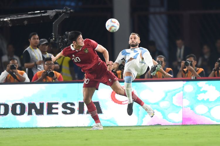 Pesepak bola Timnas Indonesia Elkan Baggott (kiri) berebut bola dengan pesepak bola Timnas Argentina German Alejo Pezzella (kanan) saat laga persahabatan FIFA Matchday di Stadion Utama Gelora Bung Karno, Jakarta, Senin (19/6/2023). TImnas Indonesia harus mengakui keunggulan Timnas Argentina dengan skor 0-2. ANTARA FOTO/Akbar Nugroho Gumay/tom.